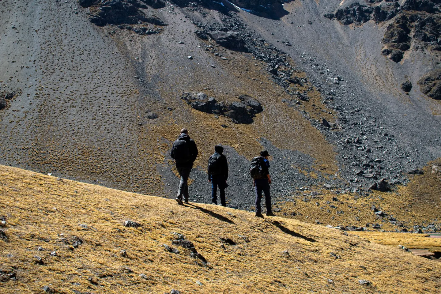 Trekkers hiking on an ancient Inca stone path through the Peruvian Andes