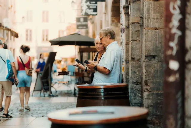 Senior couple exploring a quaint European street on a cultural tour.