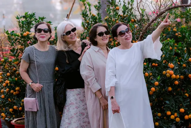 Four senior women smiling and enjoying time outdoors together on a trip.