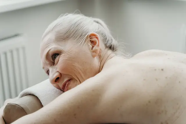 Senior woman smiling and relaxed during a spa wellness treatment.