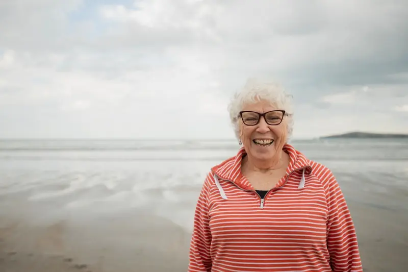 Happy senior woman smiling at the beach