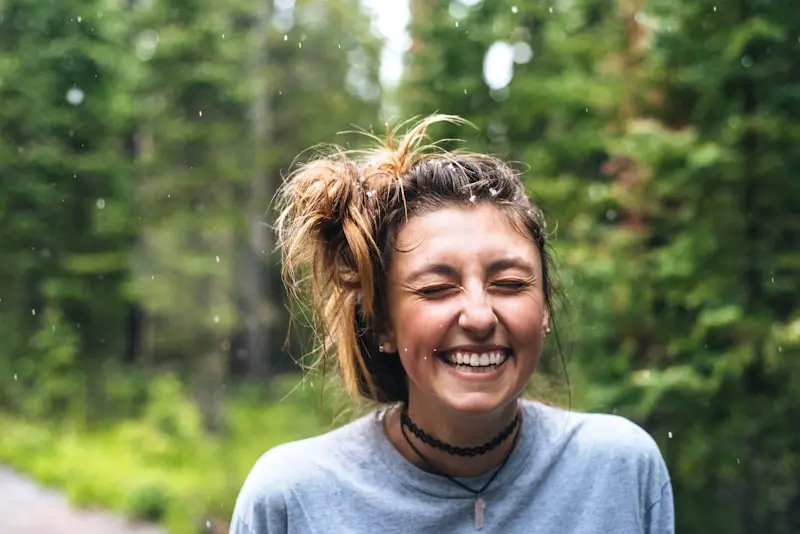 Young woman with a big smile in a lush green nature setting